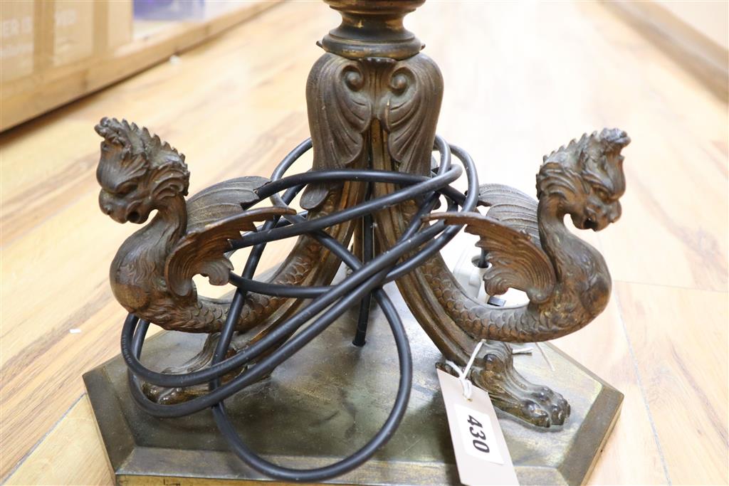 A 19th century gilt bronze and brass oil lamp on tri-form dragon supports (converted for electricity)